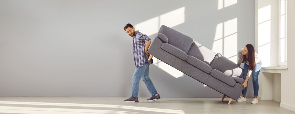 Paar trägt Sofa in neue Wohnung