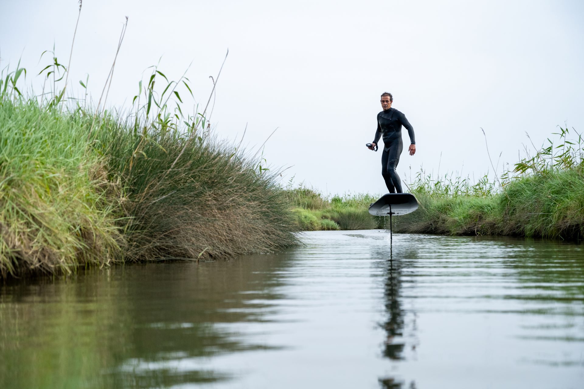 Efoil-Fahrer gleitet durch eine ruhige Flusslandschaft