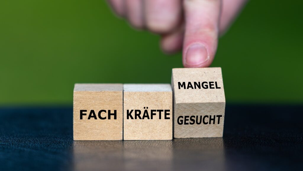 Holzsteine mit Schrift Fachkräfte Mangel | Krankenpflegehelfer Ausbildung