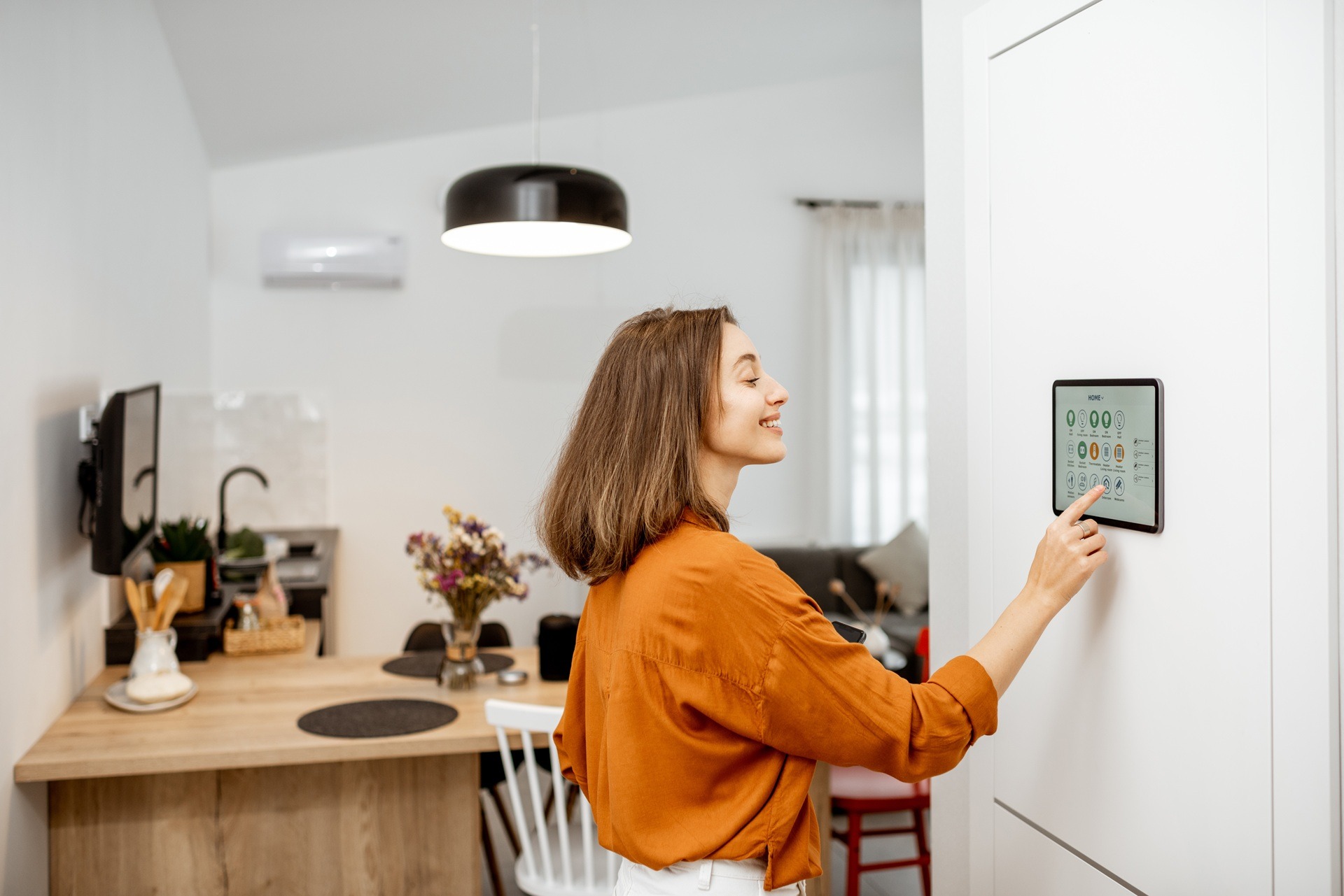 Frau bedient Smart-Home-Steuerung an Wand | PC Halterung Schreibtisch