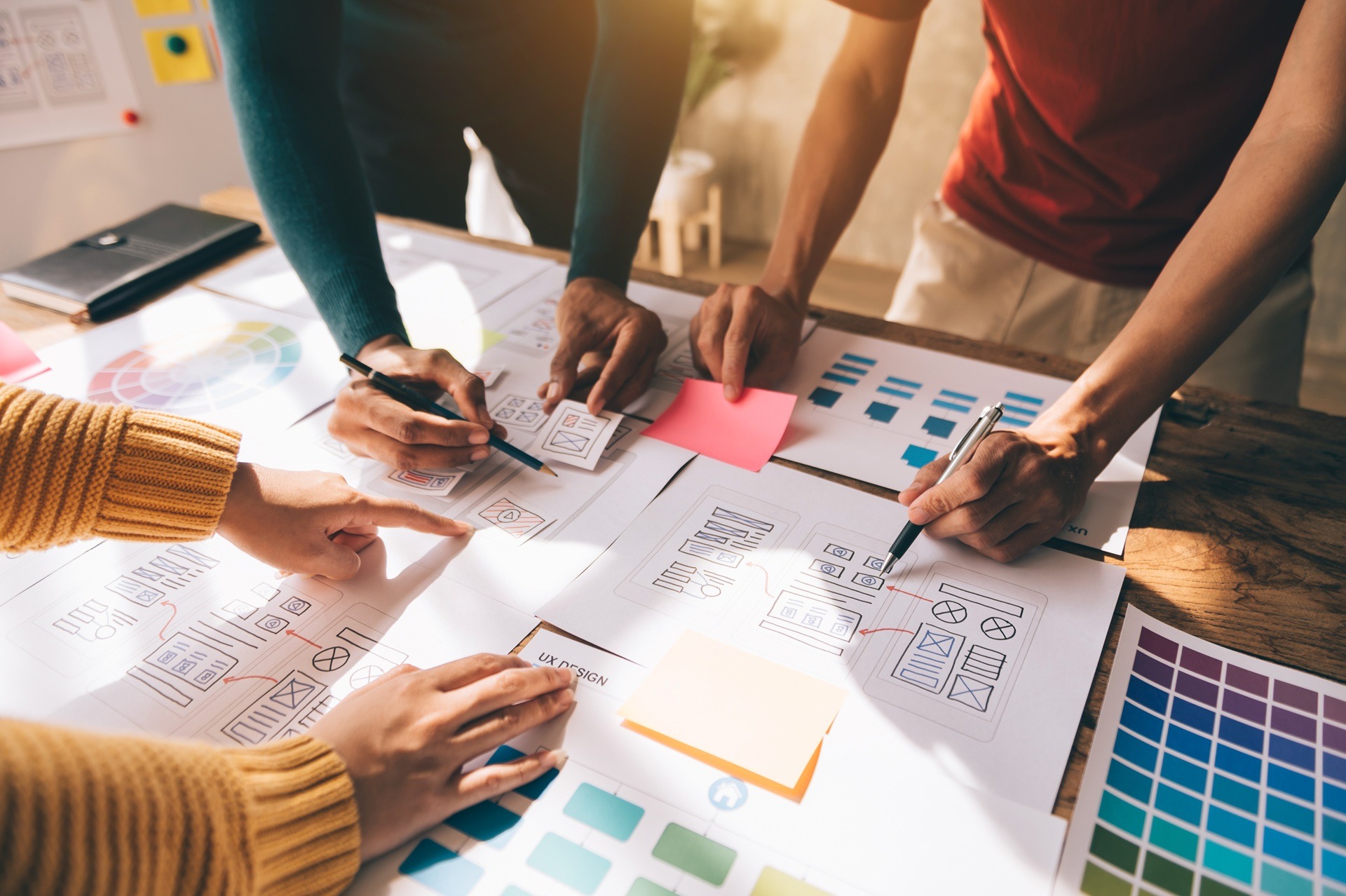 Team zeichnet Designskizzen und Markenentwürfe am Tisch | Firmenschilder