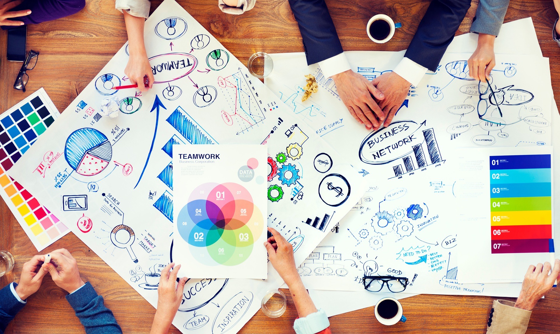 Team arbeitet an Markenstrategie mit bunten Diagrammen | Firmenschilder